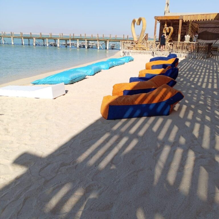 Sitzsaecke am weissen Sandstrand der Orange Bay neben dem Holzsteg