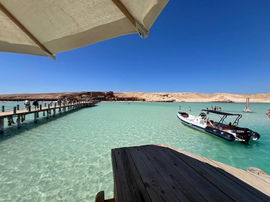Holzsteg und Speedboot im tuerkisfarbenen Wasser der Orange Bay bei Hurghada